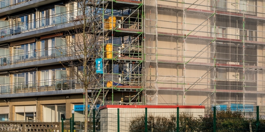 We zien een appartementsgebouw in stellingen waar de ramen van vervangen worden. We zien een appartementsgebouw in stellingen waar de ramen van vervangen worden.